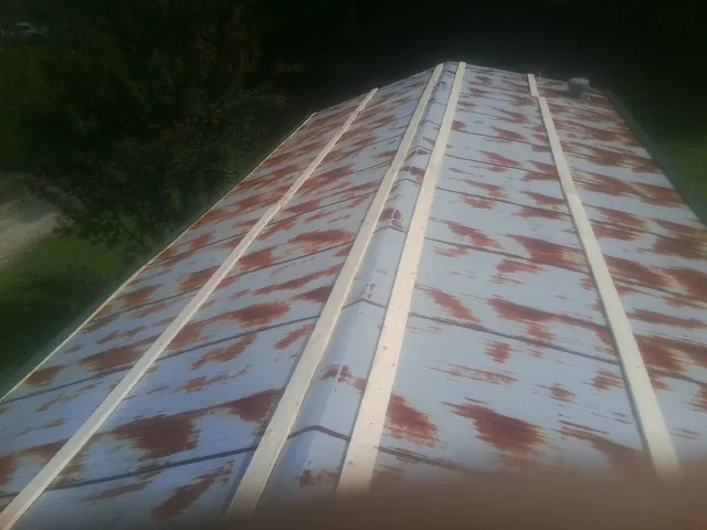 Rusted metal roof panels with new wood purlins before replacement — Storm Damage Roof Repair in West Plains by Roofing Brothers
